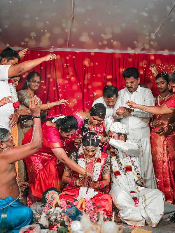 Traditional rice pouring ceremony at a Coimbatore wedding, a colorful moment frozen by Bee Bee Videos' wedding photography.