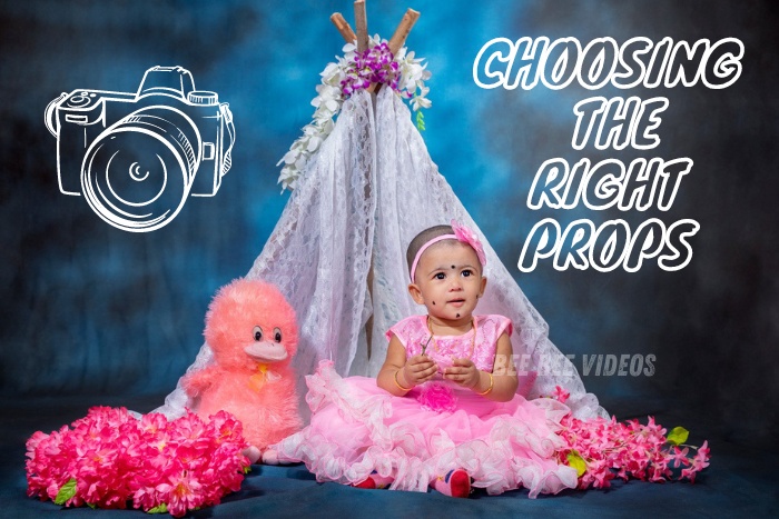 Adorable toddler in pink dress sitting next to a soft pink plush toy and colorful flowers under a decorative teepee, captured by Bee Bee Videos, expert kids photographers in Coimbatore specializing in creative prop usage
