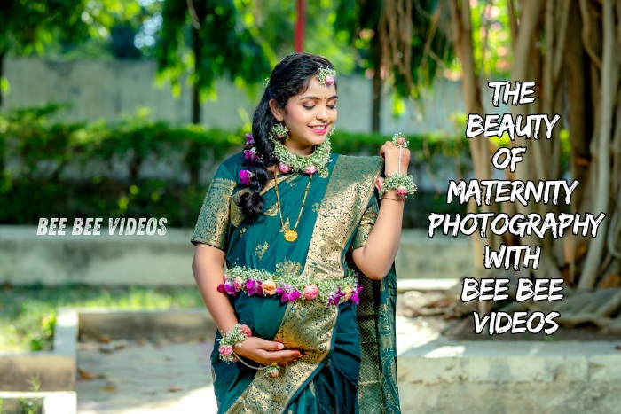 Expecting mother in traditional attire adorned with floral accessories, smiling and cradling her belly in a serene outdoor setting, captured by Bee Bee Videos & Photography in Coimbatore, showcasing the beauty of maternity photography